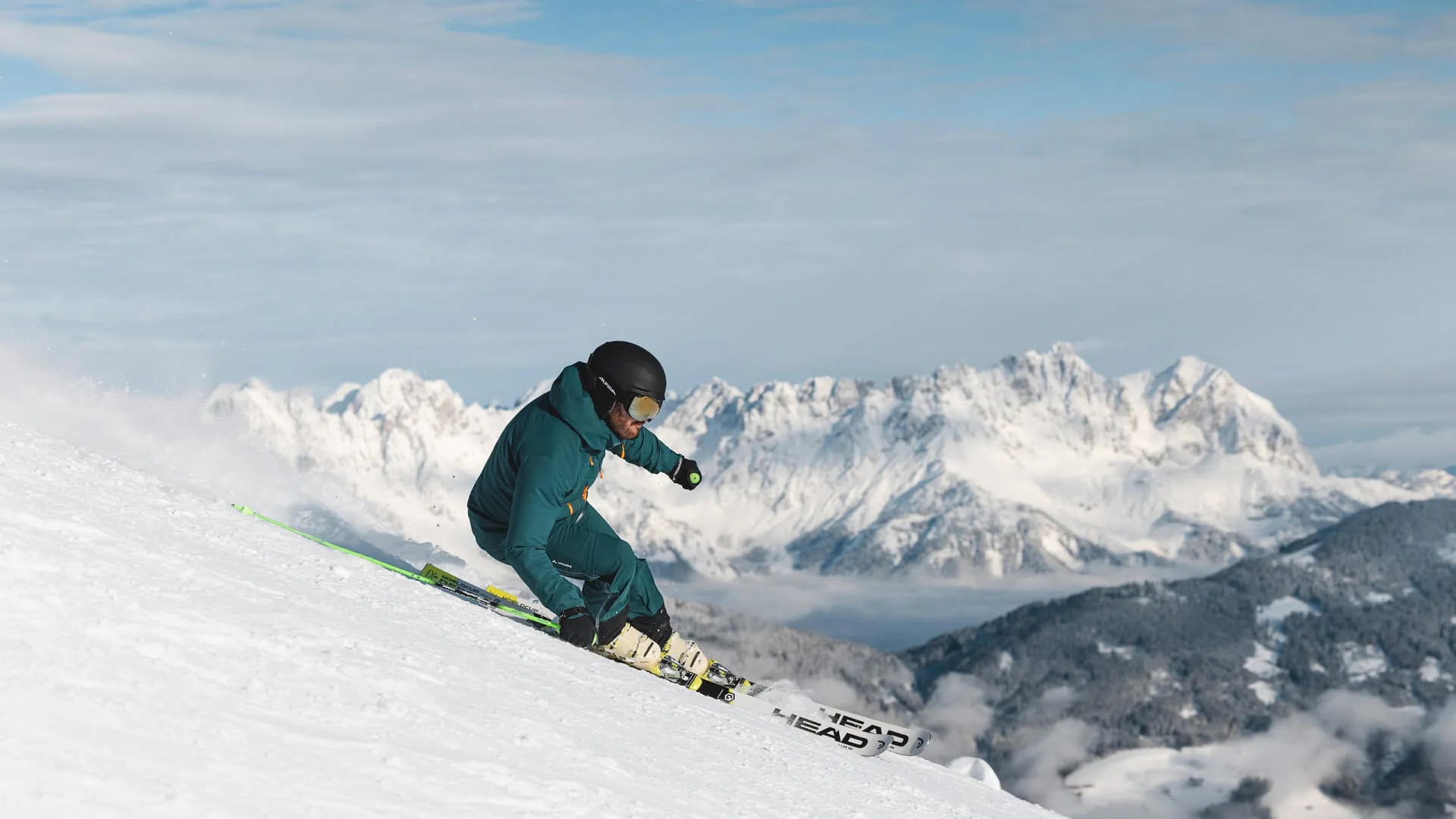 Skifahrer auf verschneitem Hang mit Bergpanorama