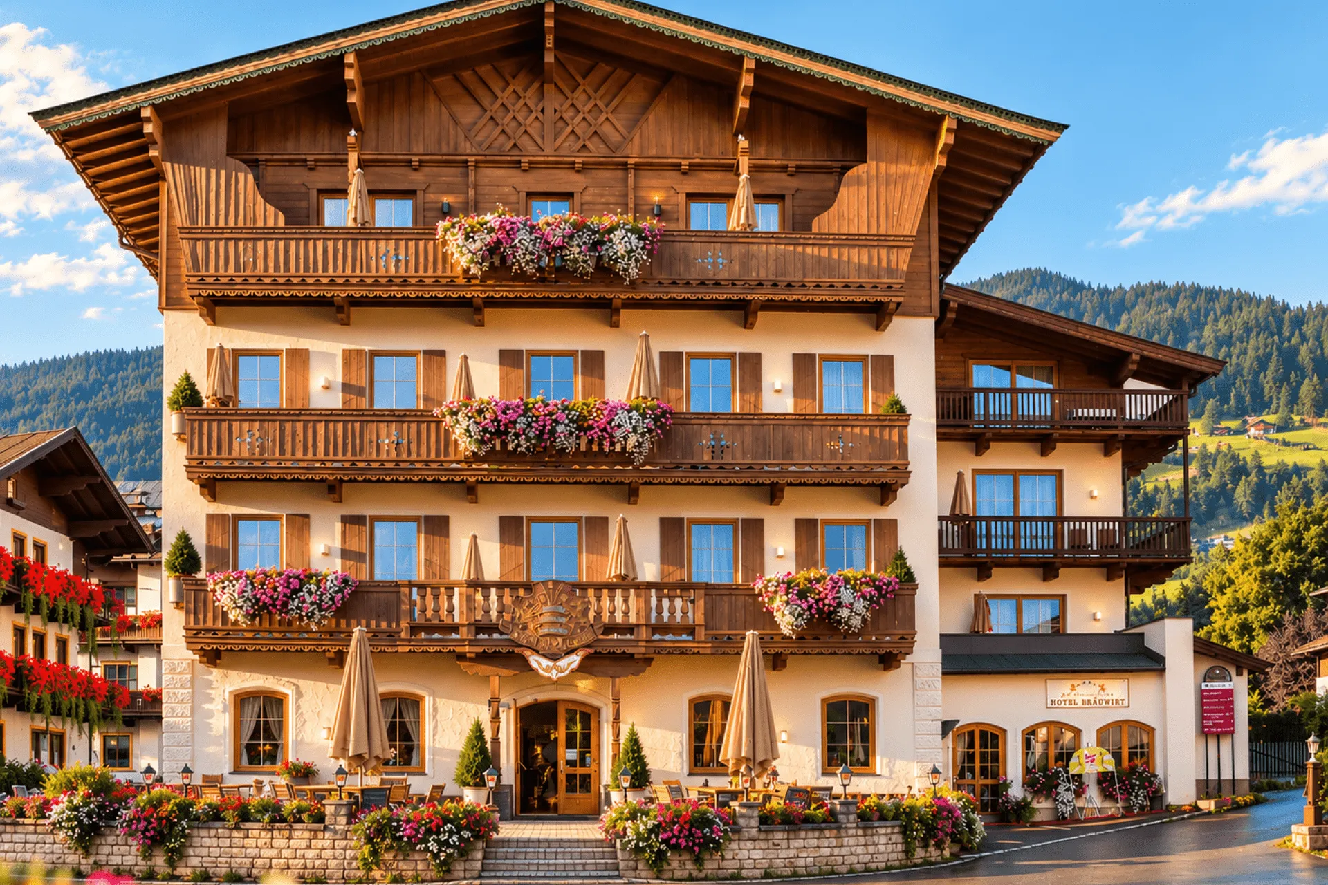 Sommeransicht eines Hotels mit Blumenschmuck und Bergen