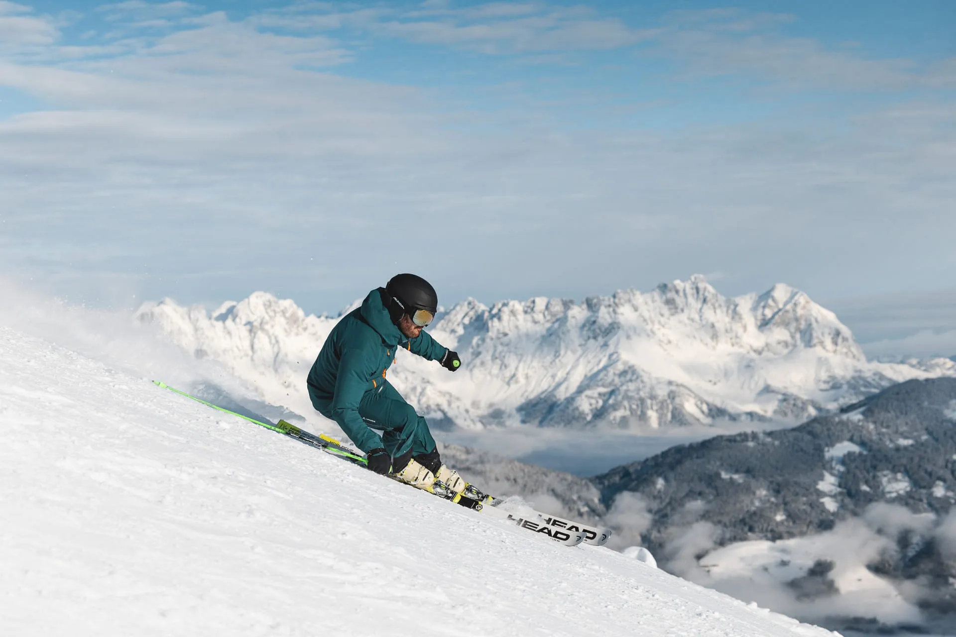 Skifahrer auf einer Piste mit Berglandschaft im Hintergrund