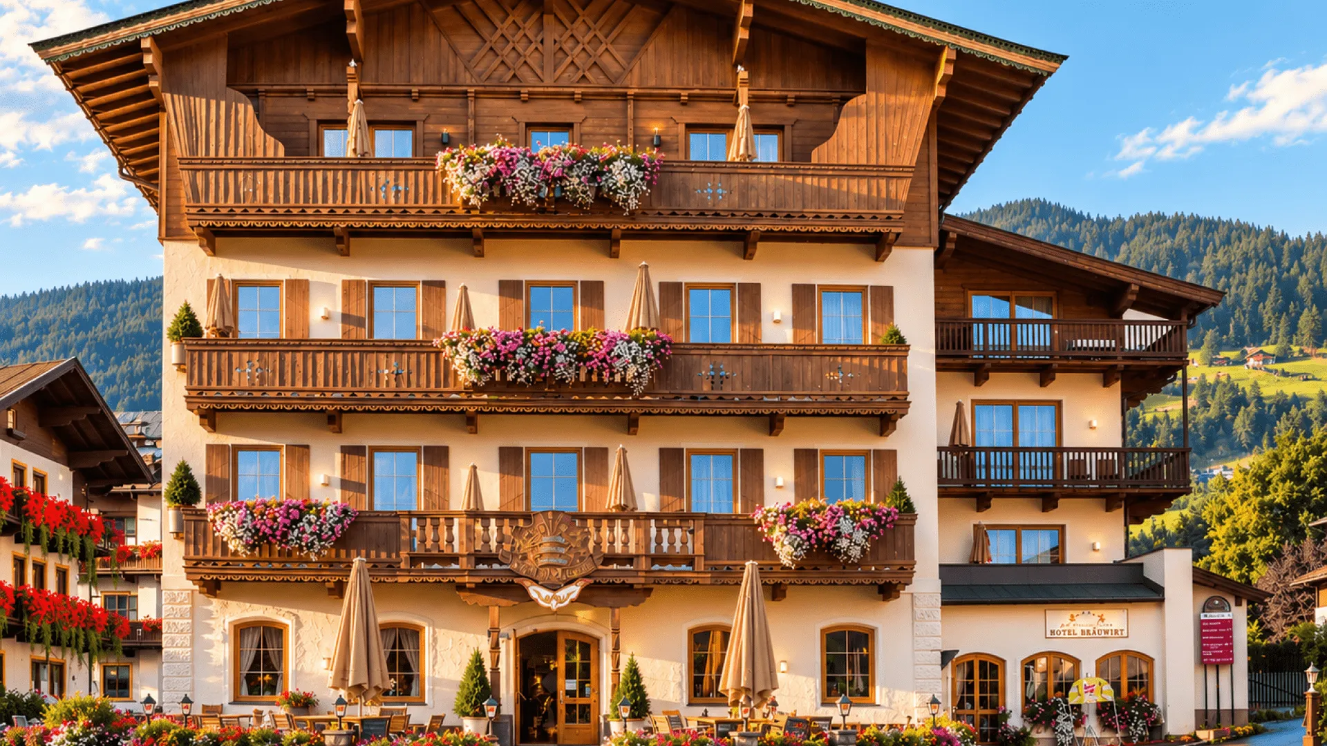 Hotel mit Balkonblumen und Alpenblick im Sommer